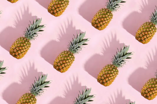 A group of pineapples on a pink background